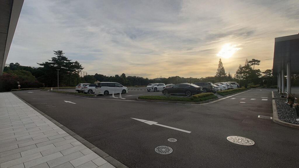 茨木国際ゴルフ倶楽部の駐車場に停められた車と朝の空