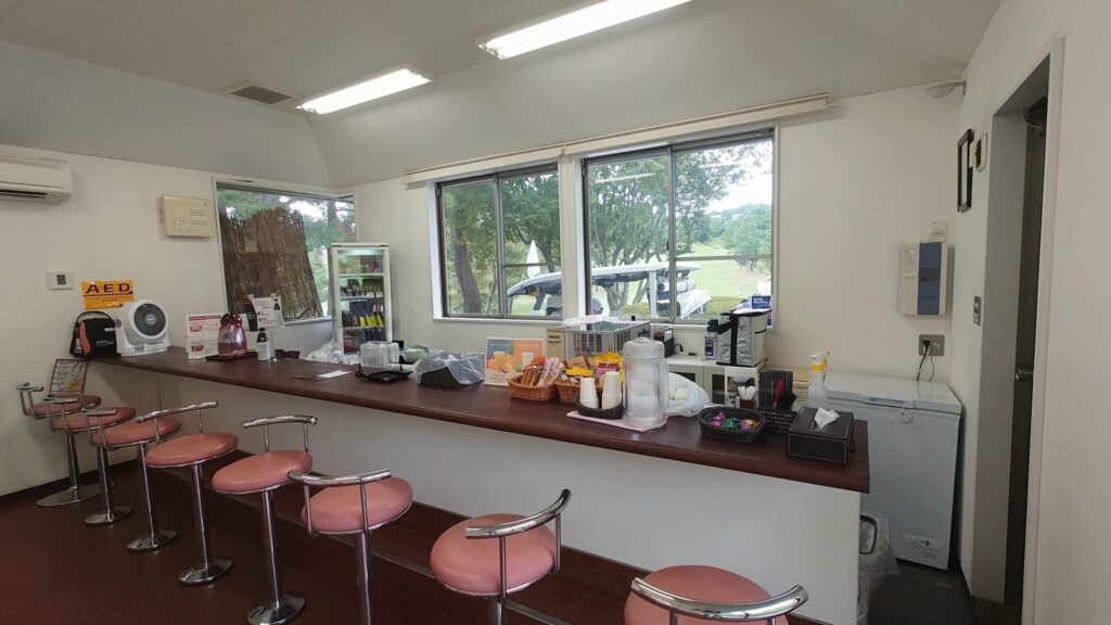 茨木国際ゴルフ倶楽部のコース売店の休憩スペースと窓から見えるコース