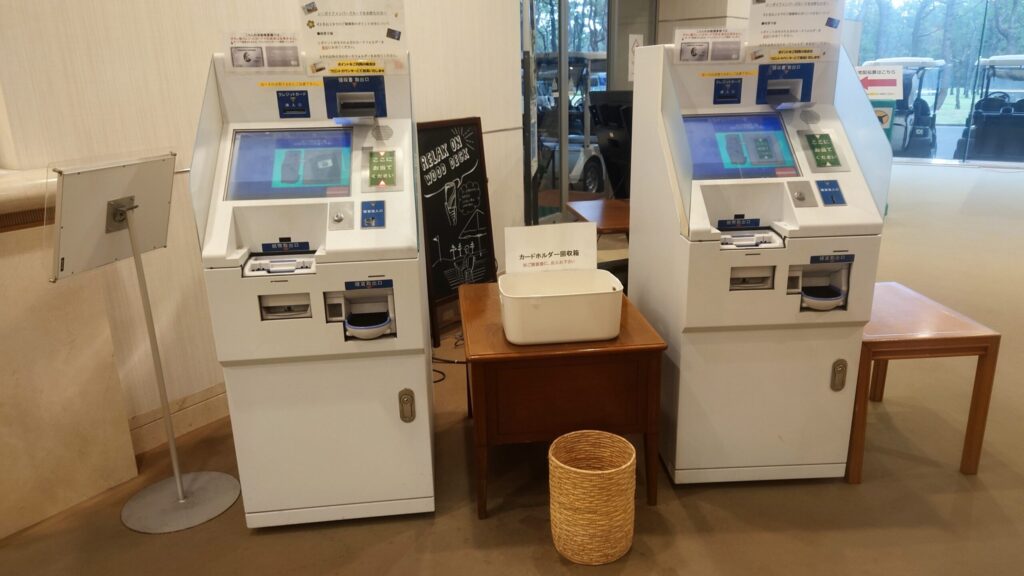 クラブハウス内に並ぶ2台の自動精算機とカードホルダー回収箱
