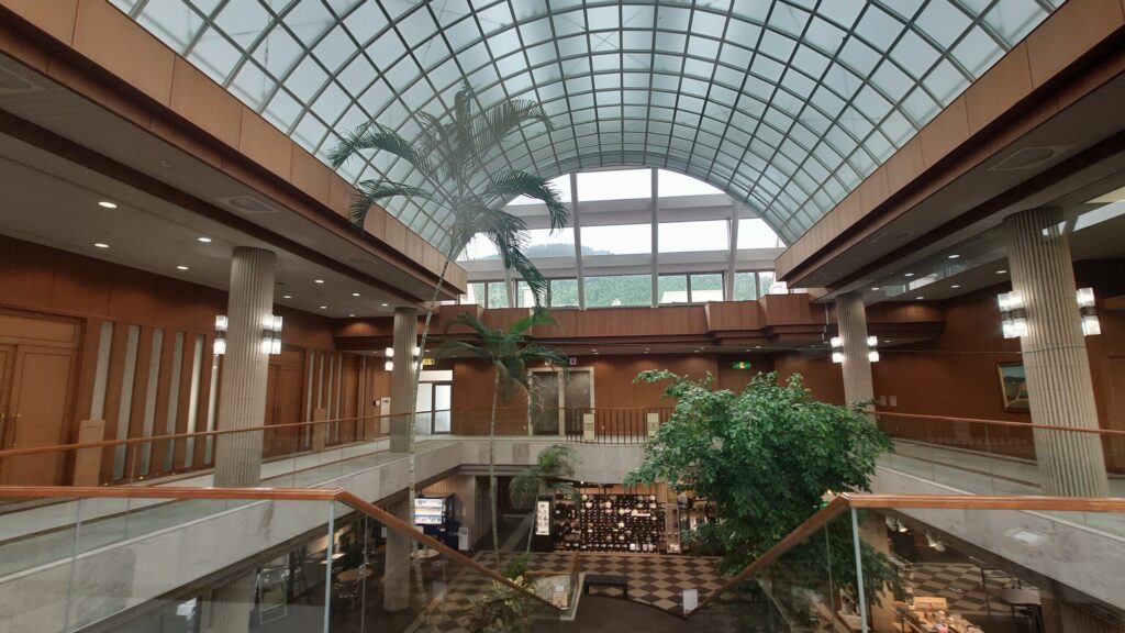 青島ゴルフ倶楽部のクラブハウスのガラス屋根の吹き抜けとヤシの木