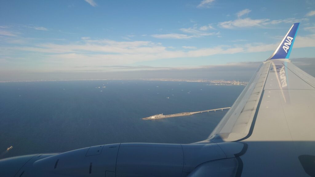 帰りの飛行機の窓から見た東京湾の海ほたると青空