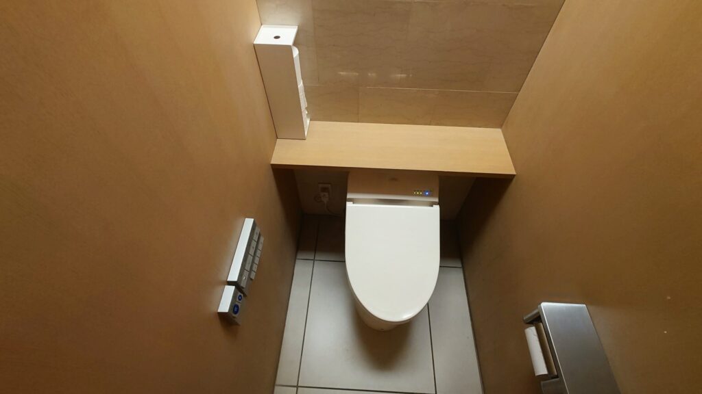 温水洗浄便座と木目のカウンターがあるトイレの個室