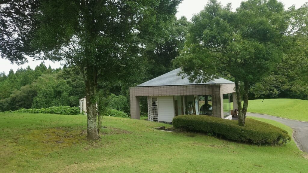 緑の木々に囲まれた売店とトイレの建物