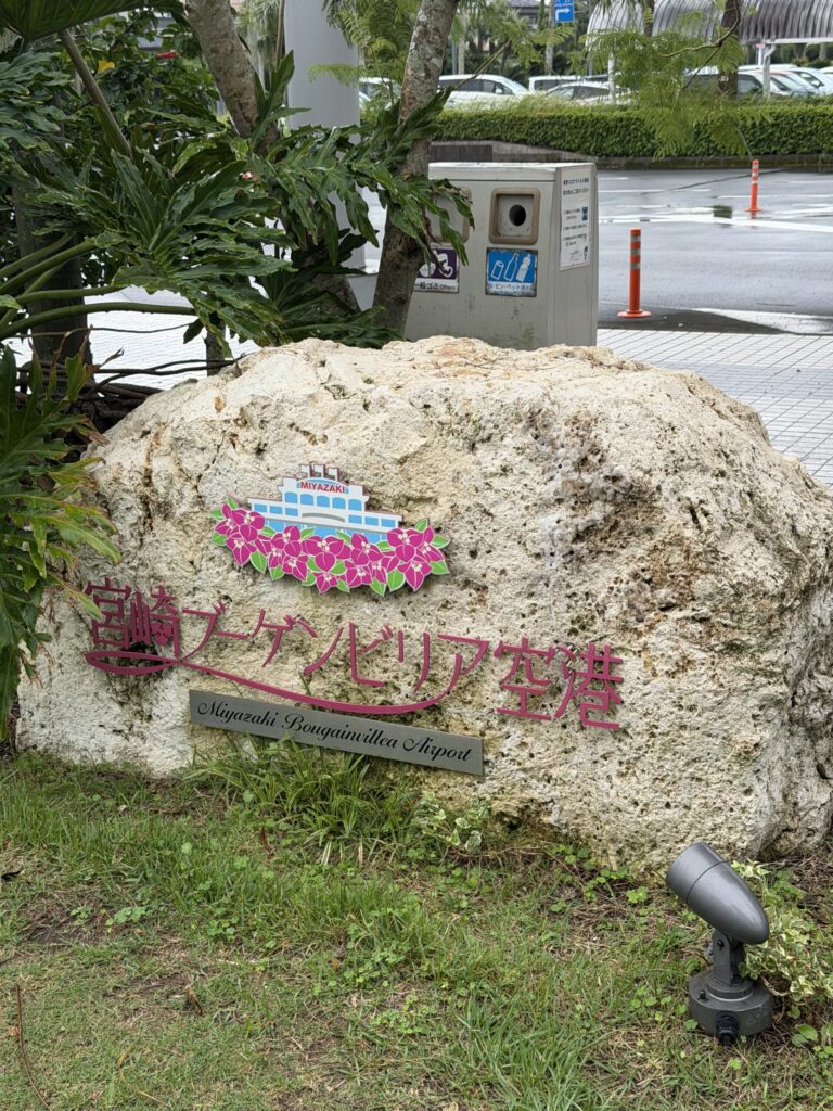 宮崎ブーゲンビリア空港の入口にある、ピンクの花のロゴが入った石碑